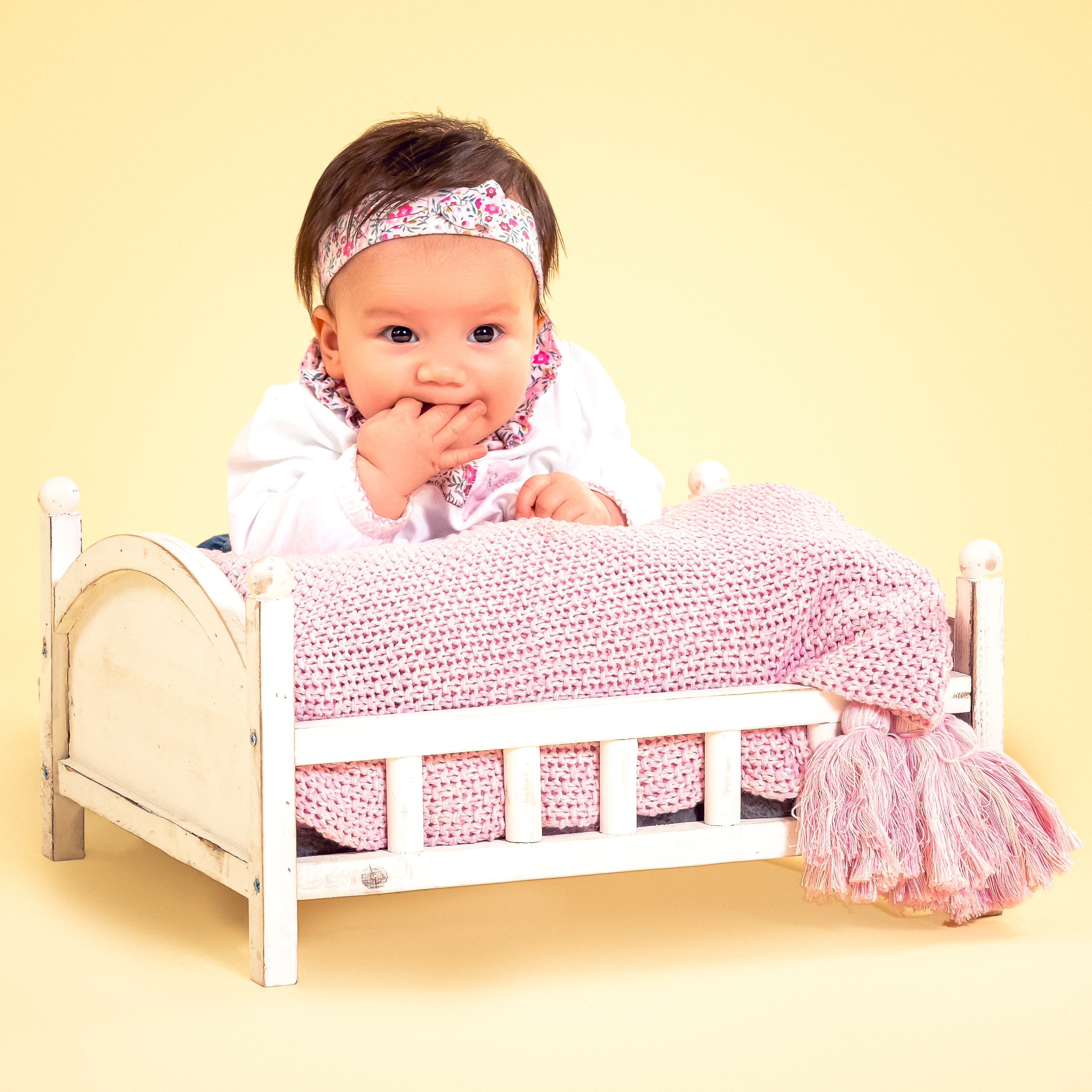 Baby girl with pink bed prop