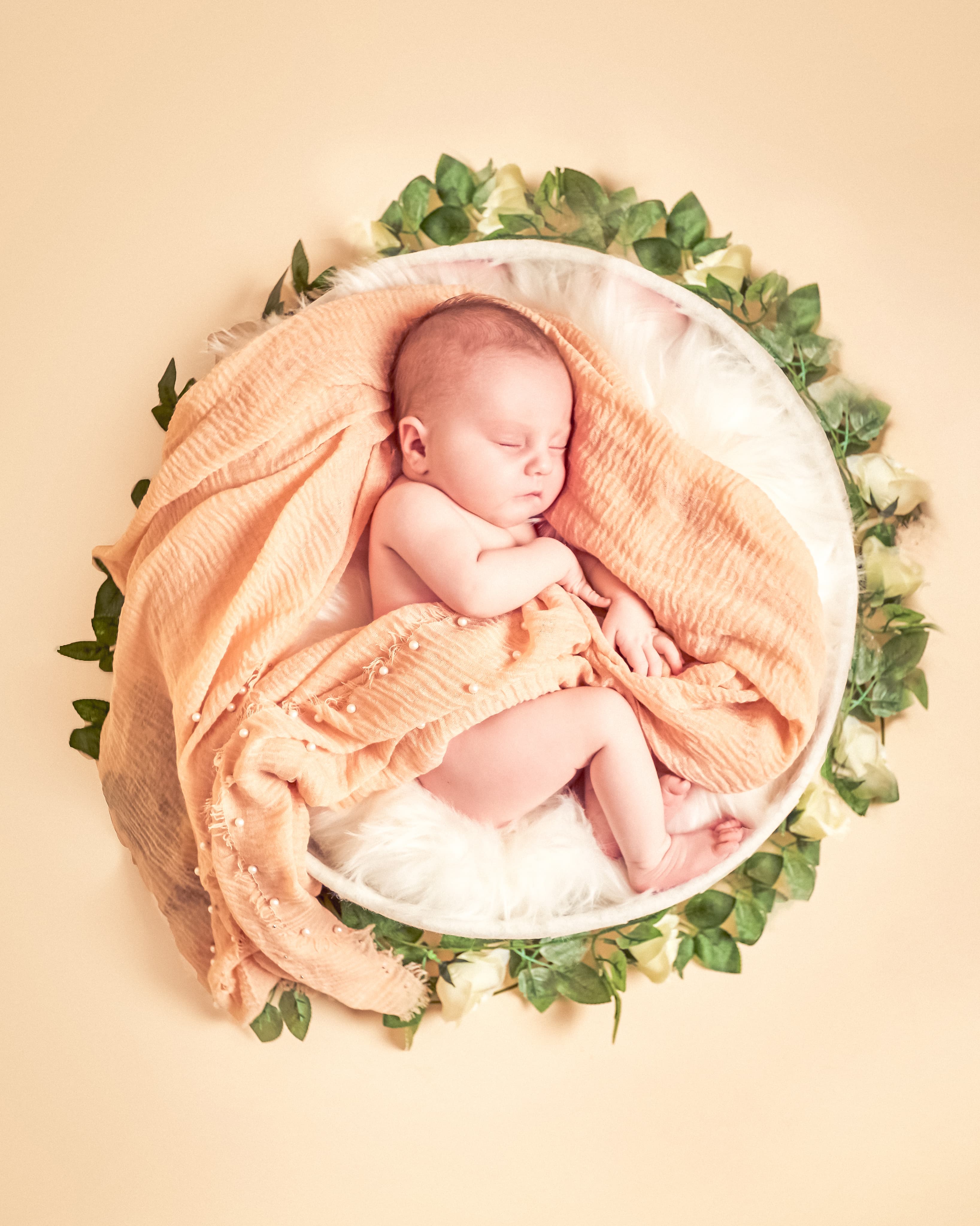 Newborn baby in floral bowl arrangement